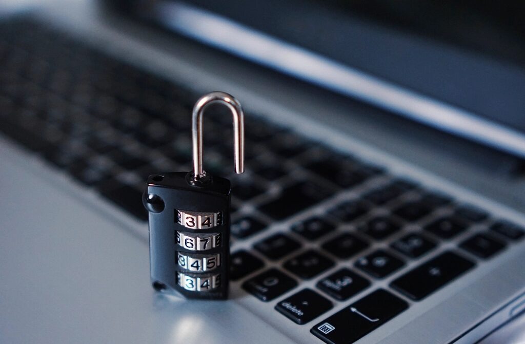 Geöffnetes Zahlenschloss steht auf der Tastatur eines Laptops